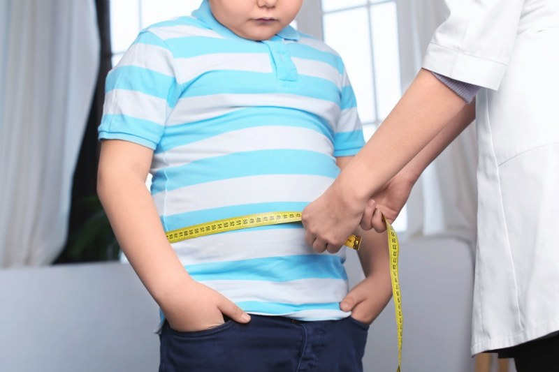 Врач осматривает ребенка с избыточным весом